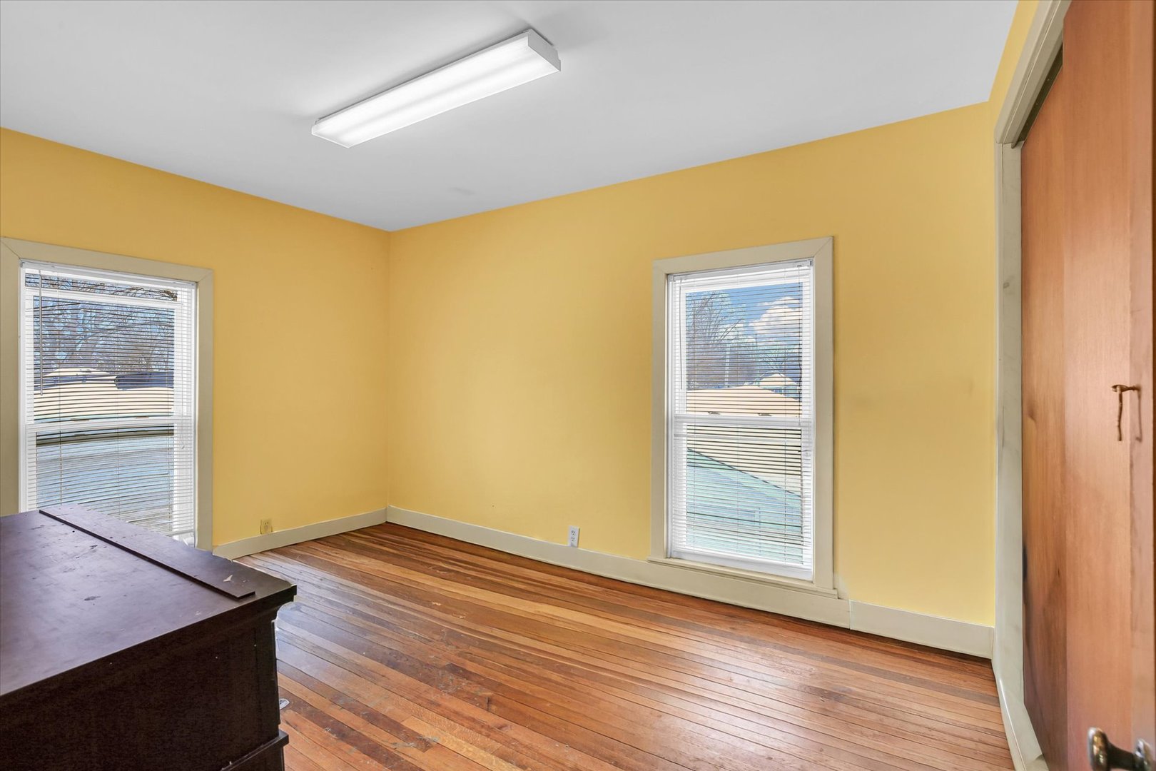 110 East Barker Street Tuscola, IL 61953 - Photo 13 of 32 a view of an empty room with wooden floor and a window