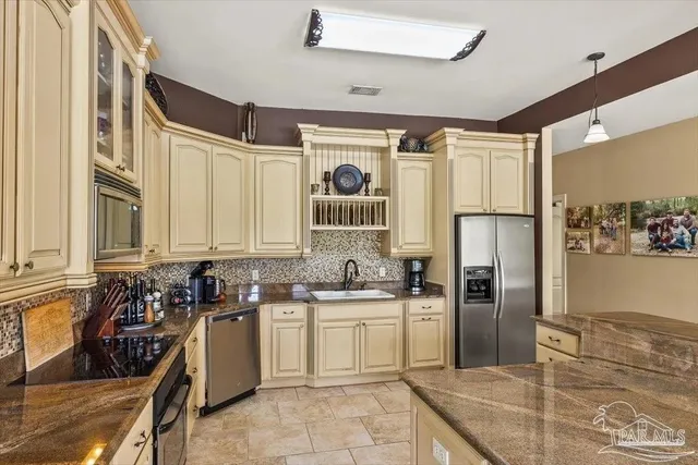 a kitchen with a sink a refrigerator and cabinets