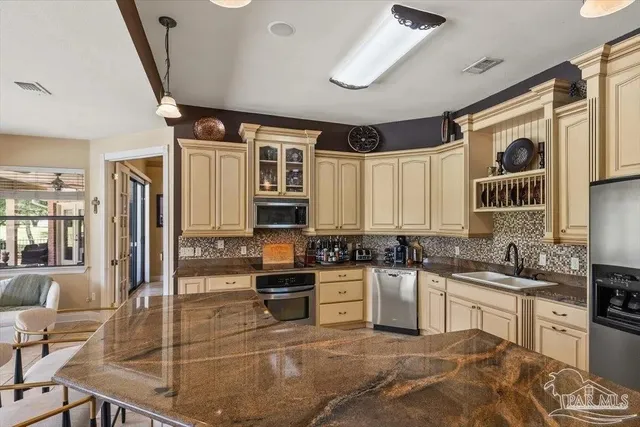 a kitchen with stainless steel appliances granite countertop a sink a stove and cabinets