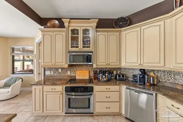 a kitchen with stainless steel appliances granite countertop a stove a sink and white cabinets