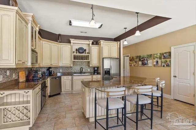 a kitchen with a dining table chairs stainless steel appliances and cabinets