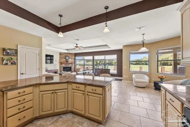 a kitchen with kitchen island granite countertop a sink and white cabinets
