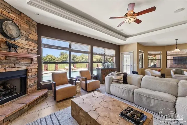 a living room with furniture a fireplace and a large window