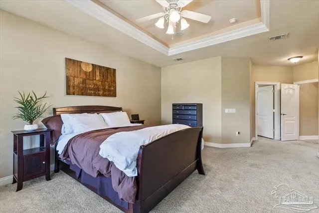 a spacious bedroom with a bed and a chandelier
