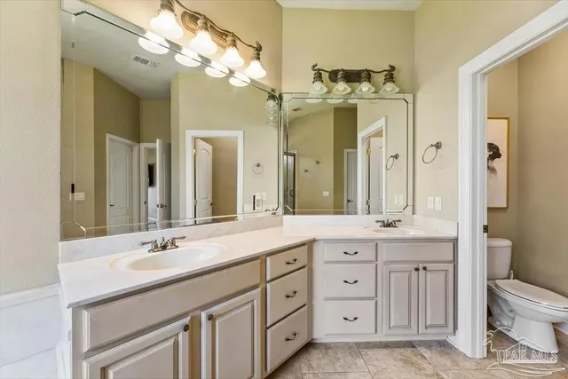 a spacious bathroom with a granite countertop sink a toilet and a mirror