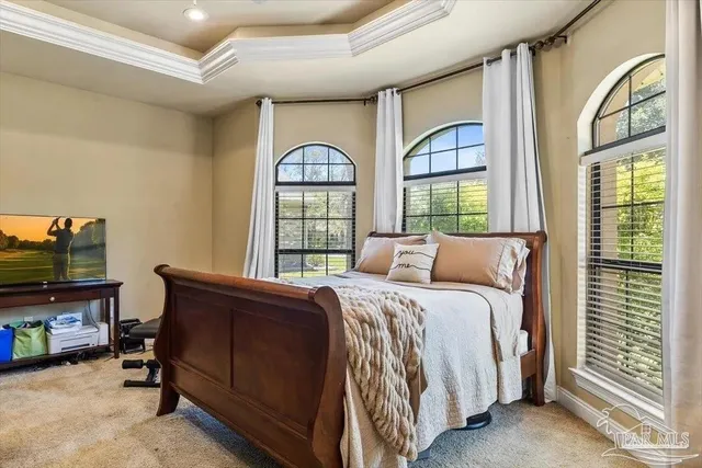 a bedroom with a bed window and a flat tv screen