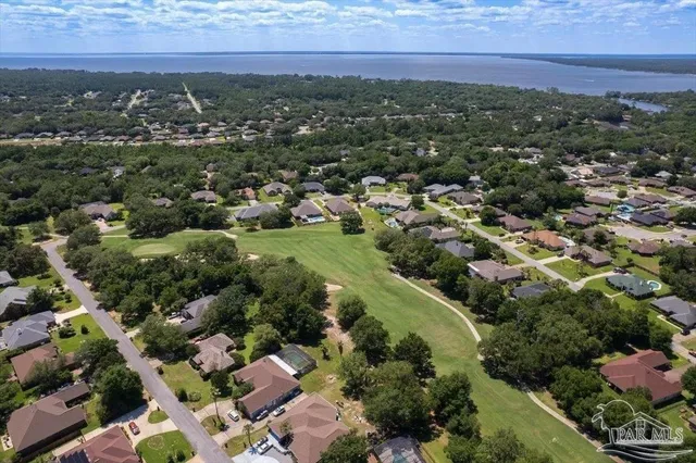 an aerial view of residential houses with outdoor space and trees