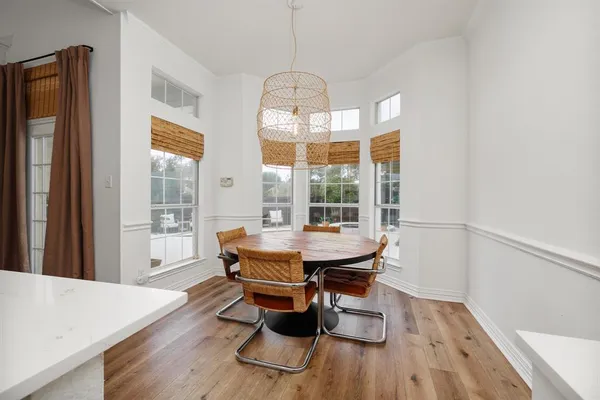 a dining room with wooden floor and a chandelier