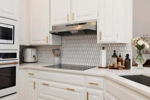 a kitchen with granite countertop a sink and a stove
