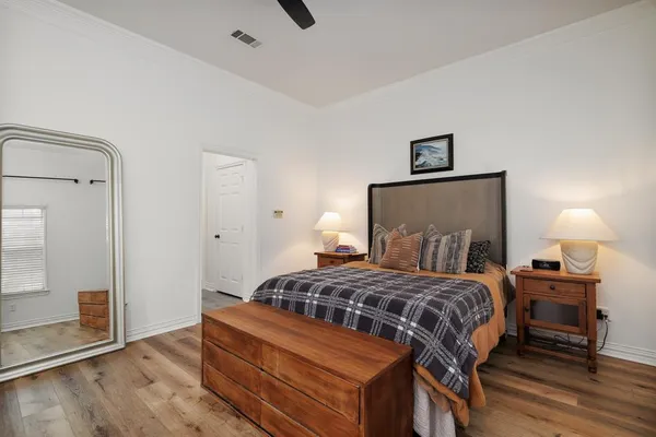 a bedroom with a bed and wooden floor