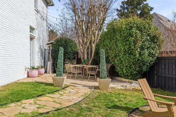 a view of a chair and table in backyard of the house