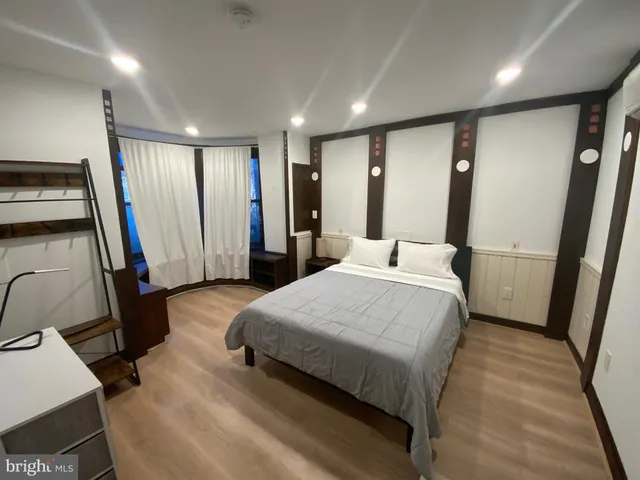 a bedroom with a bed and a large mirror