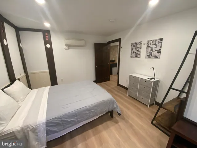 a bedroom with a bed a mirror with wooden floor