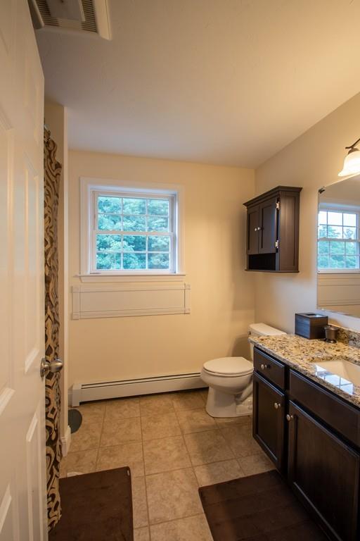 70 Frederick Street Fitchburg, MA 01420 - Photo 11 of 19 a bathroom with a granite countertop toilet sink and mirror