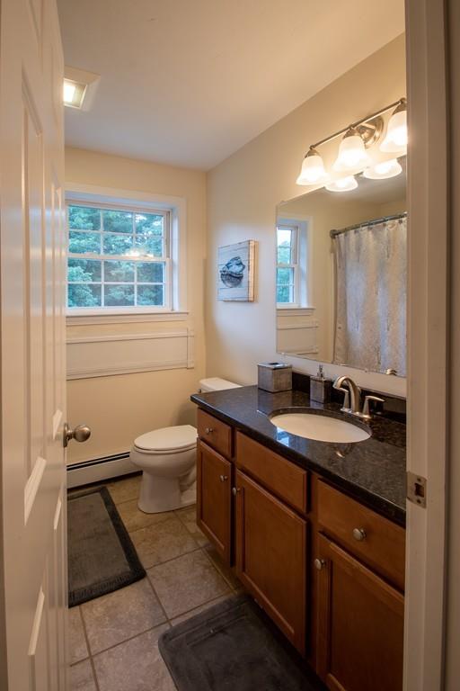 70 Frederick Street Fitchburg, MA 01420 - Photo 14 of 19 a bathroom with a granite countertop sink a toilet a mirror and a window