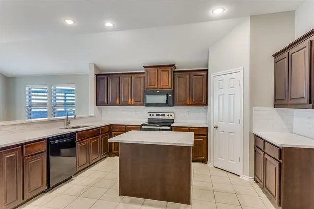 a kitchen with stainless steel appliances granite countertop a stove a sink dishwasher and a refrigerator