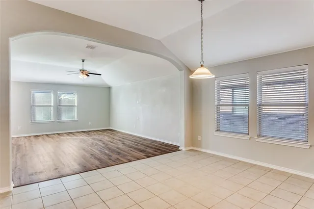 a view of an empty room with window and cabinet area