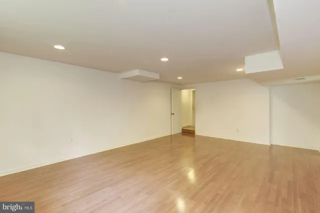 an empty room with wooden floor and natural light