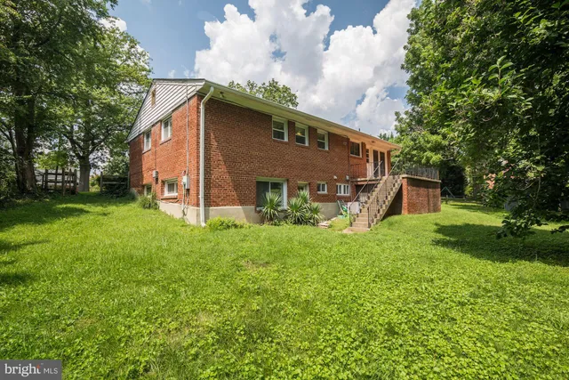 a view of a house with backyard and a tree