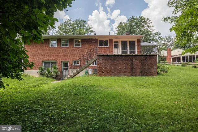 a front view of a house with a yard and trees