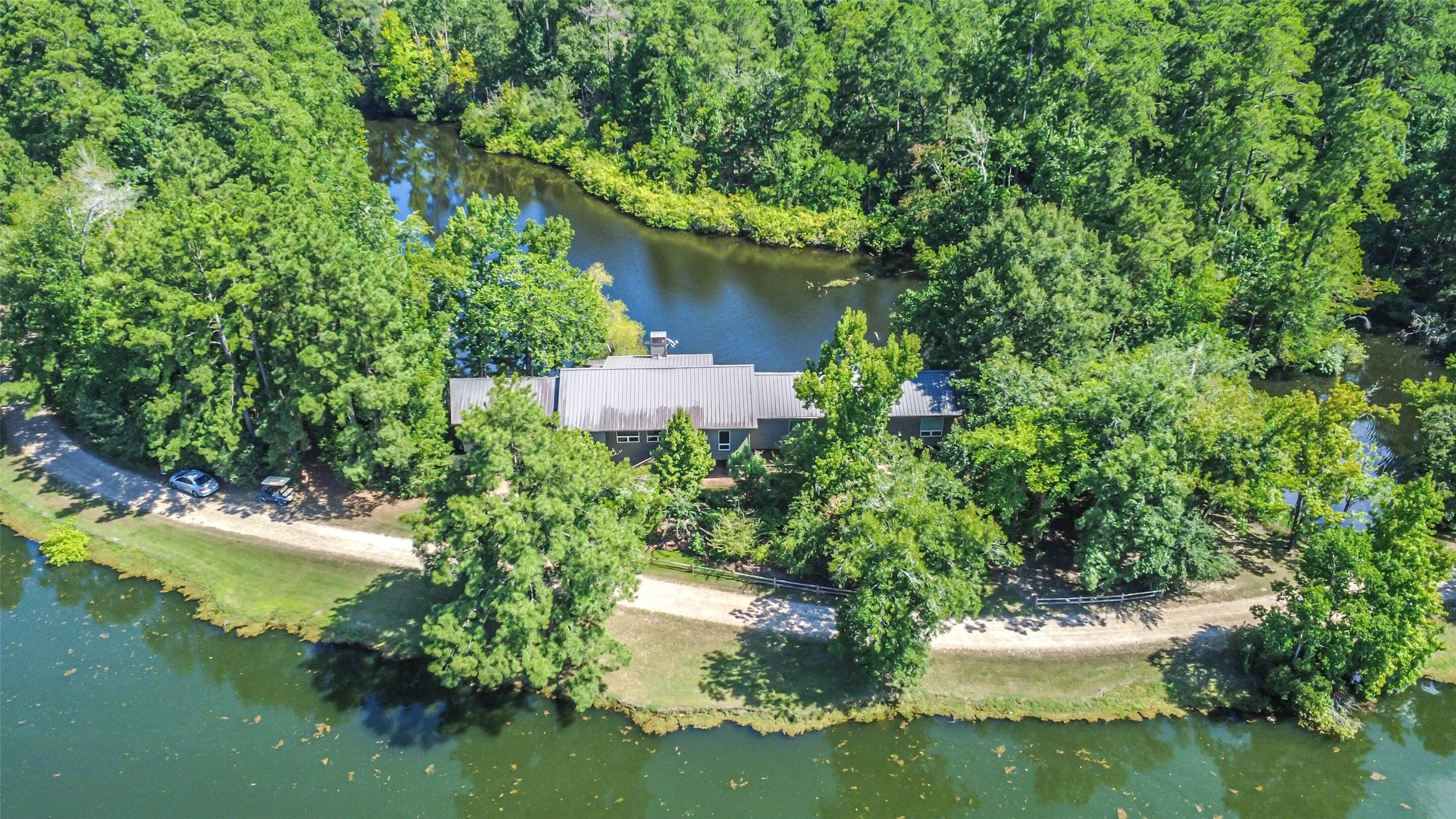 88 Raccoon Ramble Cleveland, TX 77327 - Photo 3 of 43 Secluded lakeside retreat surrounded by lush greenery and a tranquil winding waterway, offering privacy and serene natural beauty.