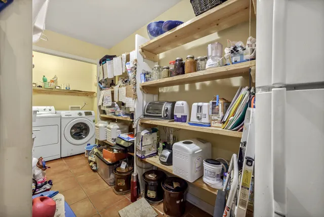 a spacious bedroom with a bed a dresser and wooden floor
