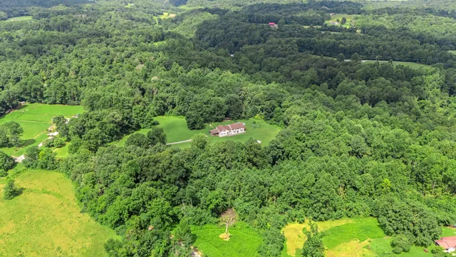 an aerial view of a house with a yard and outdoor seating