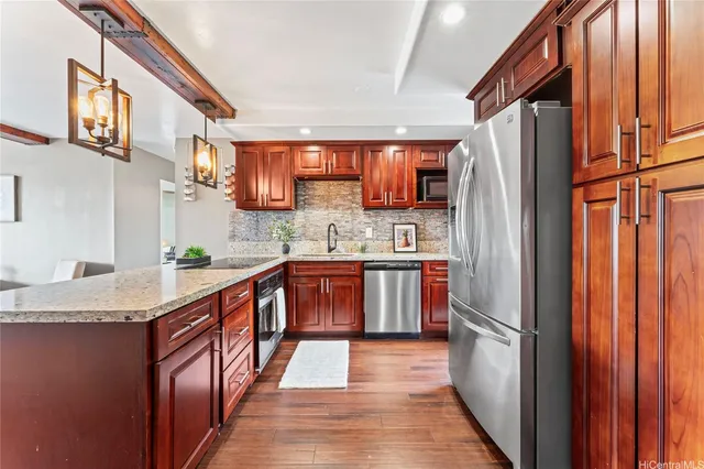 a kitchen with stainless steel appliances granite countertop a refrigerator a sink and a stove
