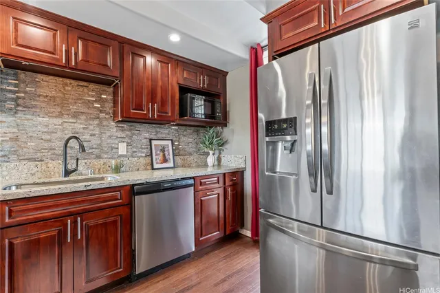 a kitchen with stainless steel appliances granite countertop a refrigerator and a sink