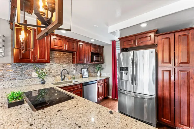 a kitchen with stainless steel appliances granite countertop a refrigerator and a sink