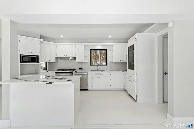 a kitchen with stainless steel appliances a refrigerator sink and microwave