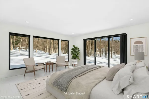 a bedroom with a bed and a large window