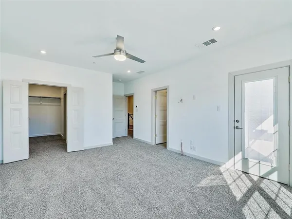 en empty room with windows and ceiling fan