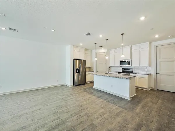 a large kitchen with stainless steel appliances a refrigerator and a stove top oven