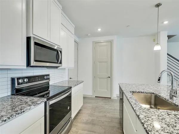 a kitchen with a sink stove and microwave