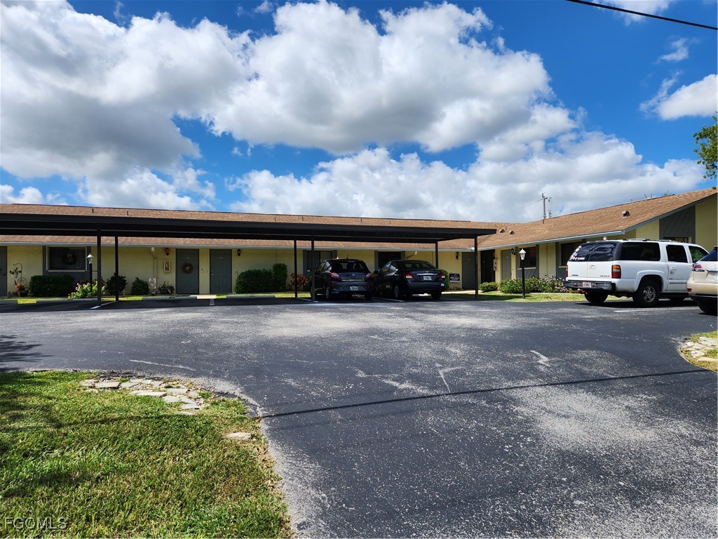 1420 Academy Boulevard, Unit 106 Cape Coral, FL 33990 - Photo 2 of 21 a view of street with parked cars