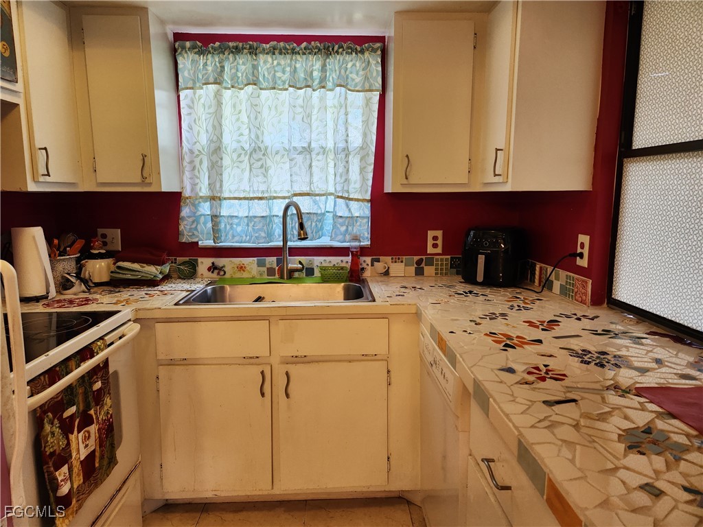 1420 Academy Boulevard, Unit 106 Cape Coral, FL 33990 - Photo 8 of 21 a kitchen with a sink stove and cabinets