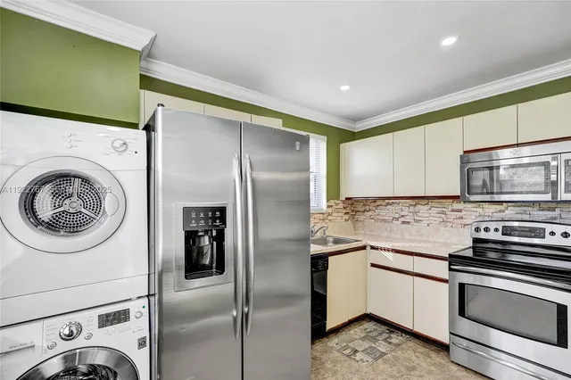 a kitchen with stainless steel appliances granite countertop a refrigerator and a stove top oven