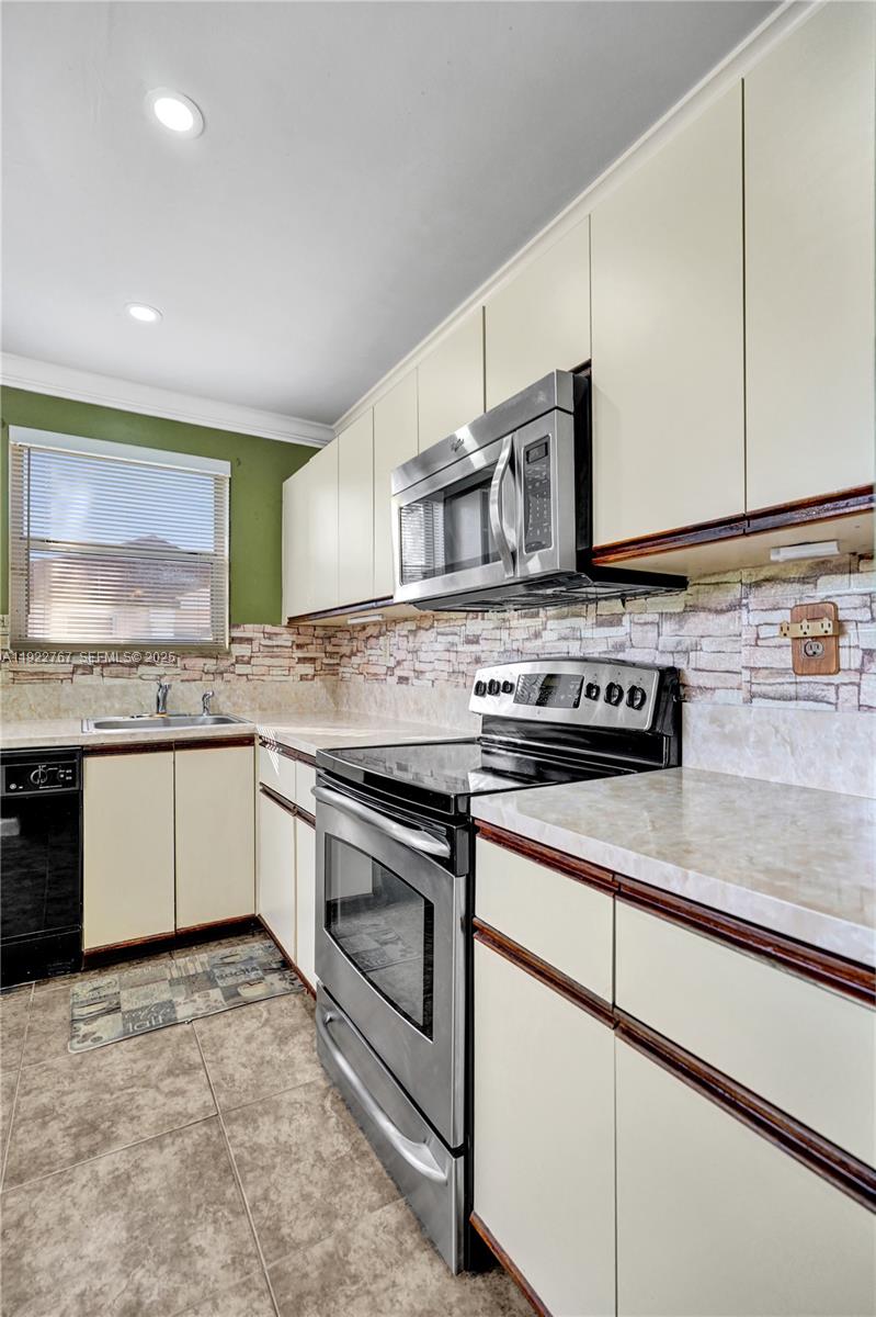 11201 Southwest 13th Street, Unit 204 Pembroke Pines, FL 33025 - Photo 18 of 33 a kitchen with stainless steel appliances granite countertop a stove a sink and a microwave