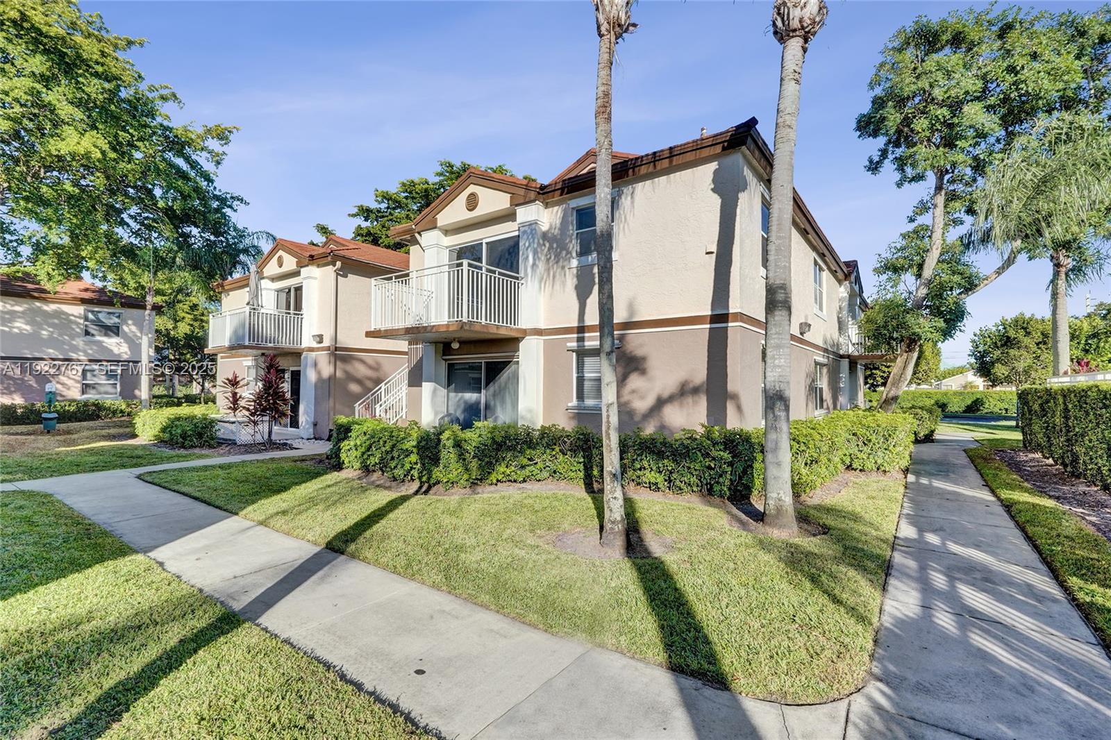 11201 Southwest 13th Street, Unit 204 Pembroke Pines, FL 33025 - Photo 2 of 33 a front view of a house with a yard