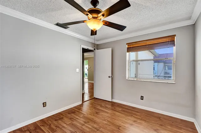 a view of empty room with wooden floor
