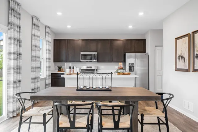 a kitchen with a table chairs microwave and cabinets
