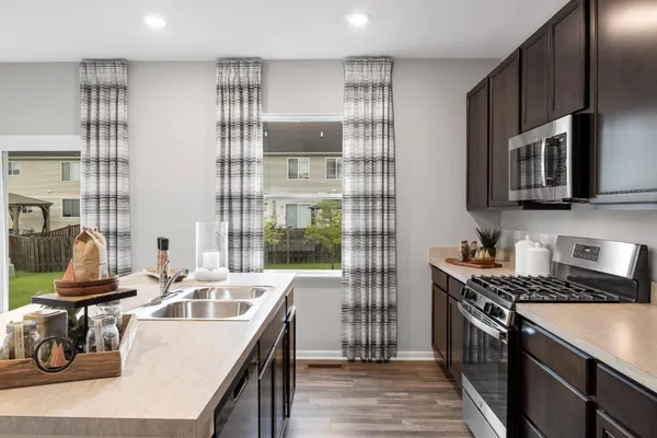 a kitchen with stainless steel appliances granite countertop a sink stove and cabinets