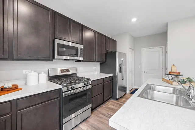 a kitchen with granite countertop wooden cabinets stainless steel appliances and a counter space