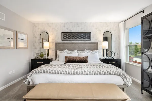a bedroom with a bed and a large mirror
