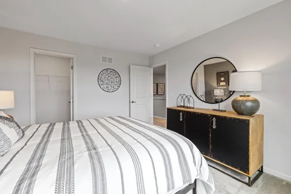 a view of a bedroom with a bed and wooden floor