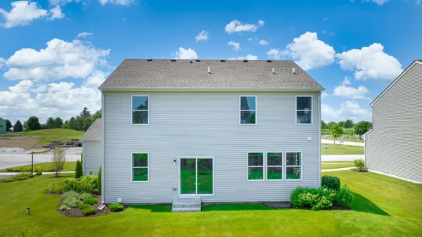 a view of a house with a yard and potted plants