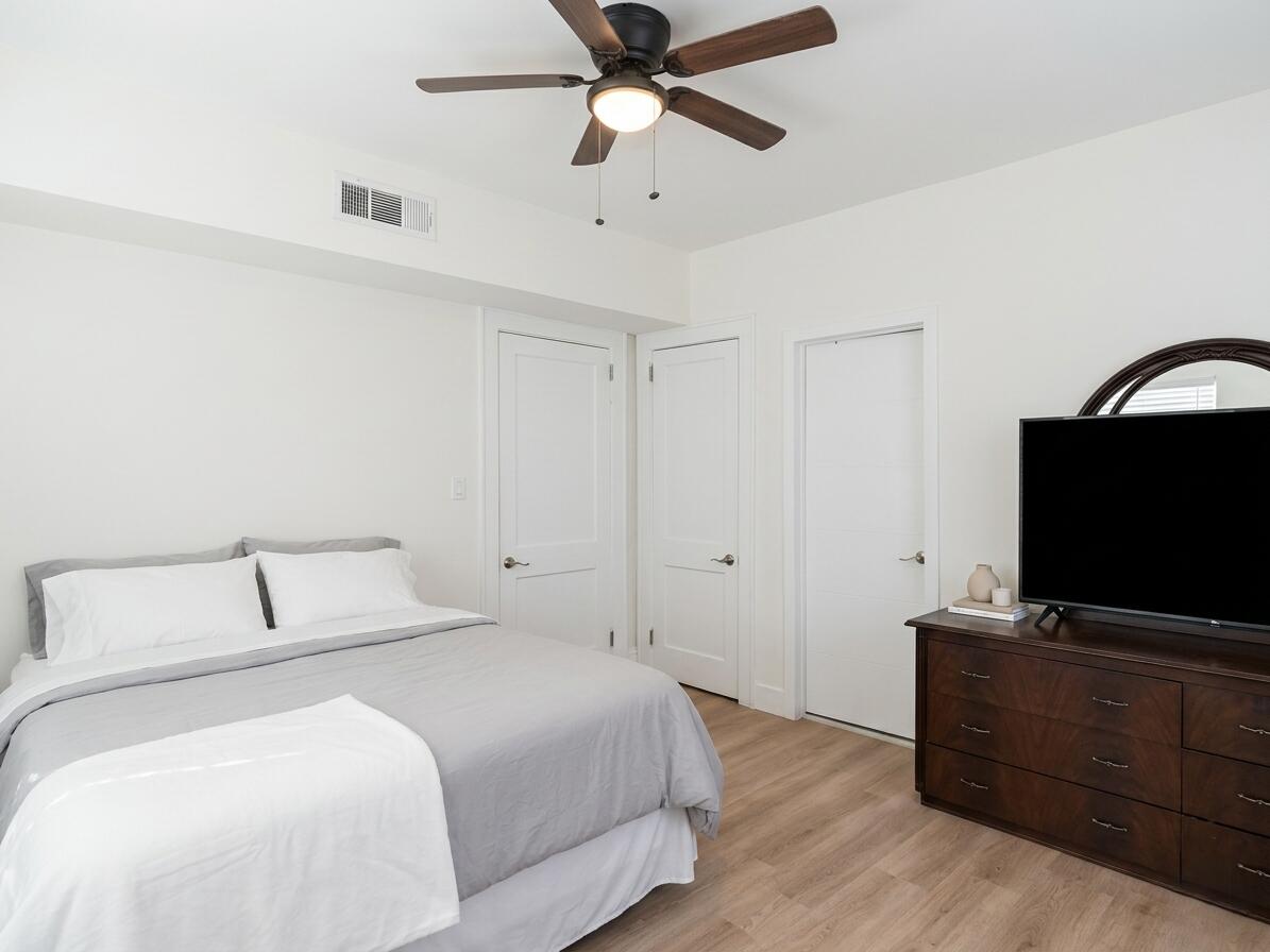 817 Tyler Street, Unit 2 Hollywood, FL 33019 - Photo 4 of 9 a bedroom with a bed and a flat tv screen on the dresser