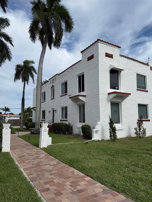 817 Tyler Street, Unit 2 Hollywood, FL 33019 - Photo 9 of 9 a front view of a house with a garden and plants