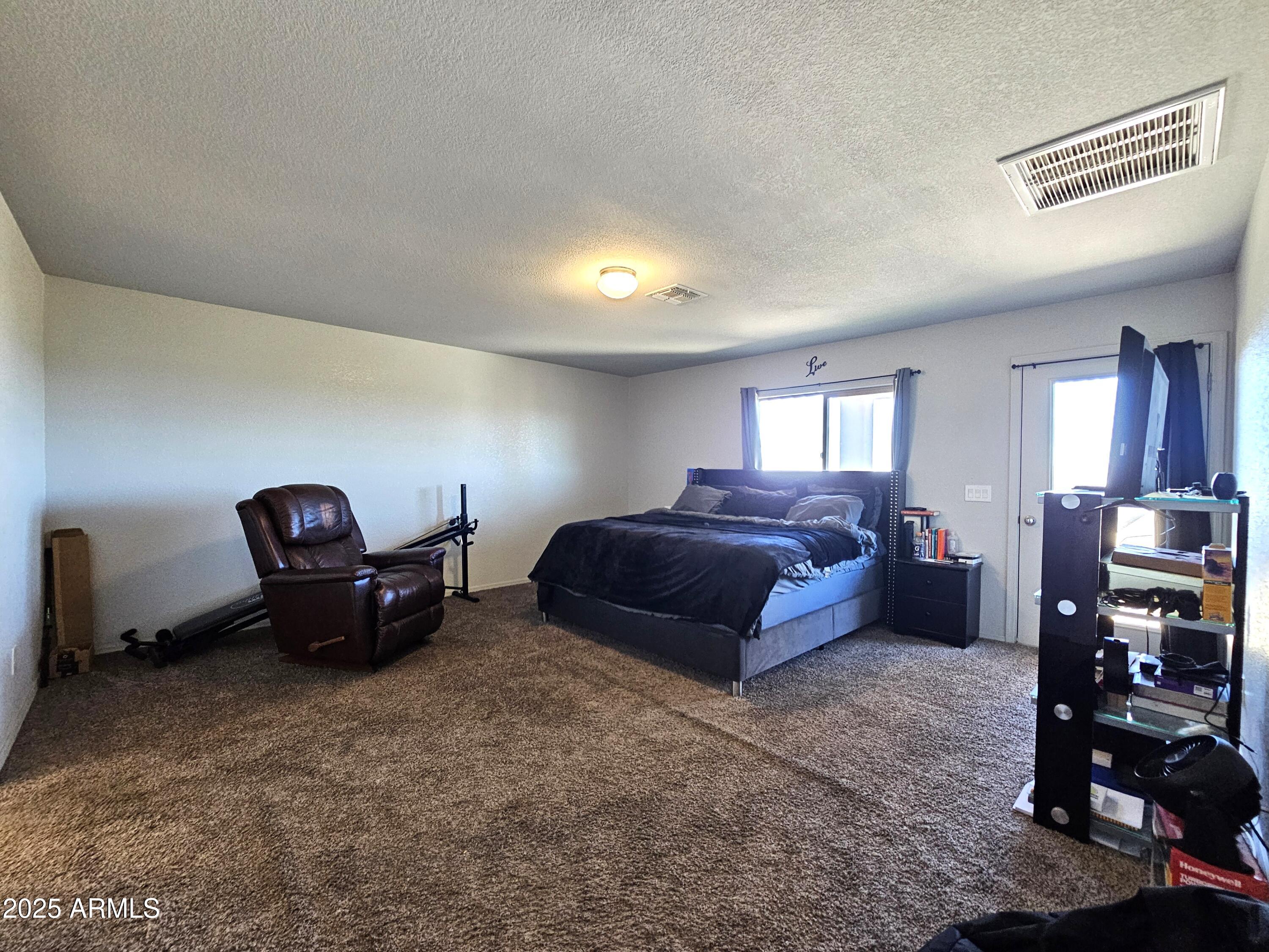 3443 Rhapsody Drive Sierra Vista, AZ 85650 - Photo 12 of 28 a spacious bedroom with a bed and a mirror